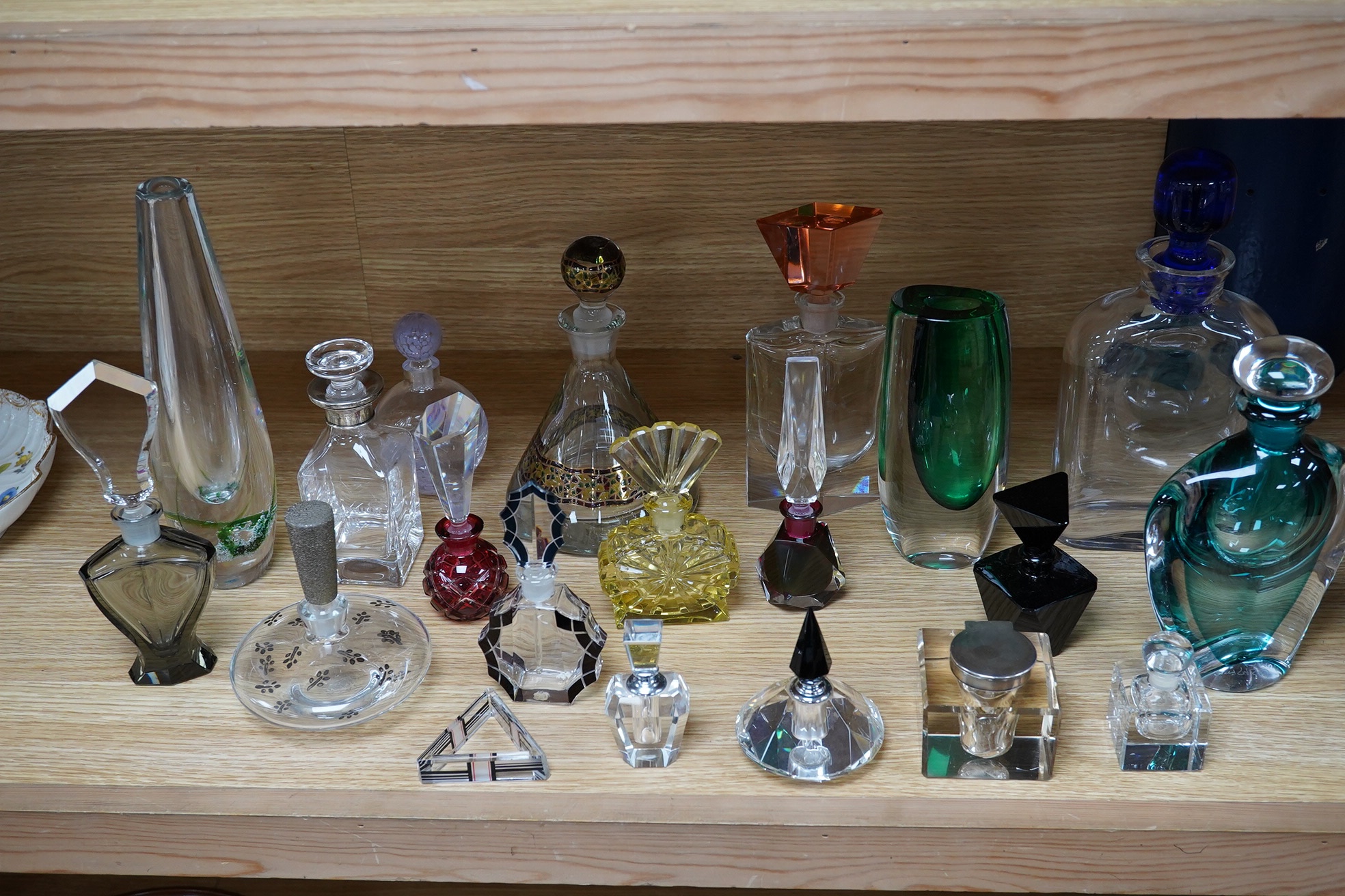 Eighteen glass scent bottles, two silver mounted, tallest 24.5cm, and a glass vase. Condition - good